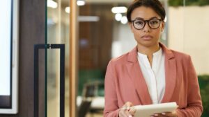 African women in office facing the camera with a notebook and pen in her hands