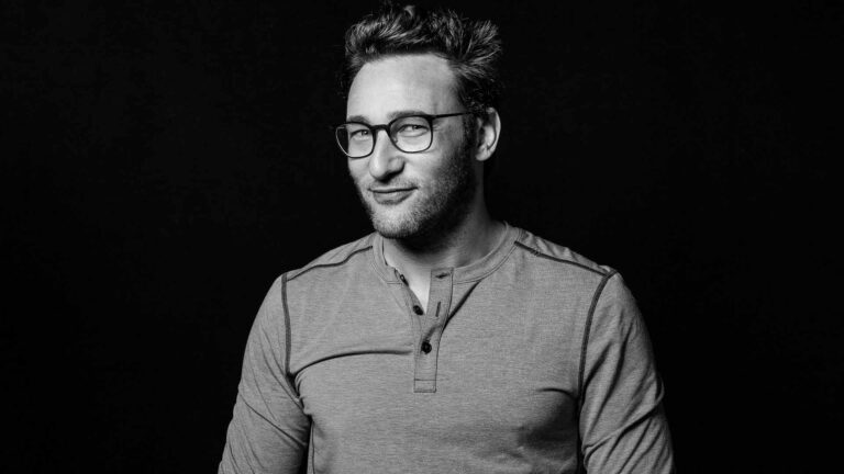 Simon Sinek (man) smiling at camera