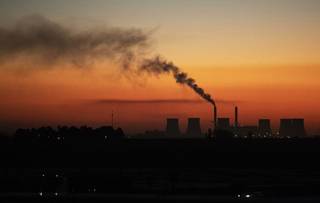 Power station emitting smoke at sunset representing eskom's load reduction measures to prevent transformer overloads during winter.