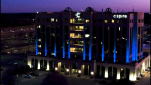 Night view of the c spire headquarters building with blue and white lighting highlighting its modern architecture
