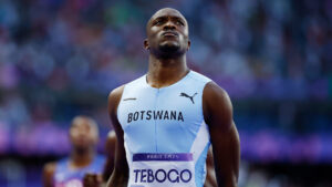 Tebogo letsile standing proudly in his botswana uniform after winning the 200 meter final at the paris 2024 olympics