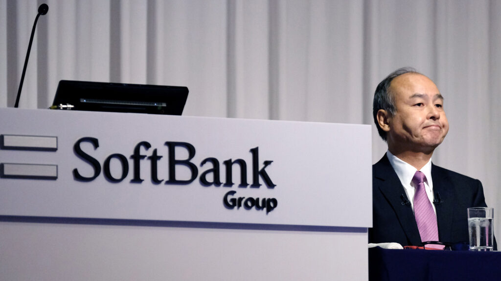 Softbank ceo masayoshi son at a press conference with a softbank group logo on the podium