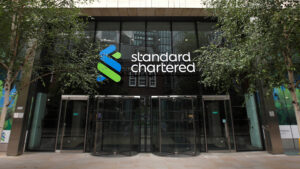 Entrance of standard chartered bank headquarters with the companys logo on the building facade