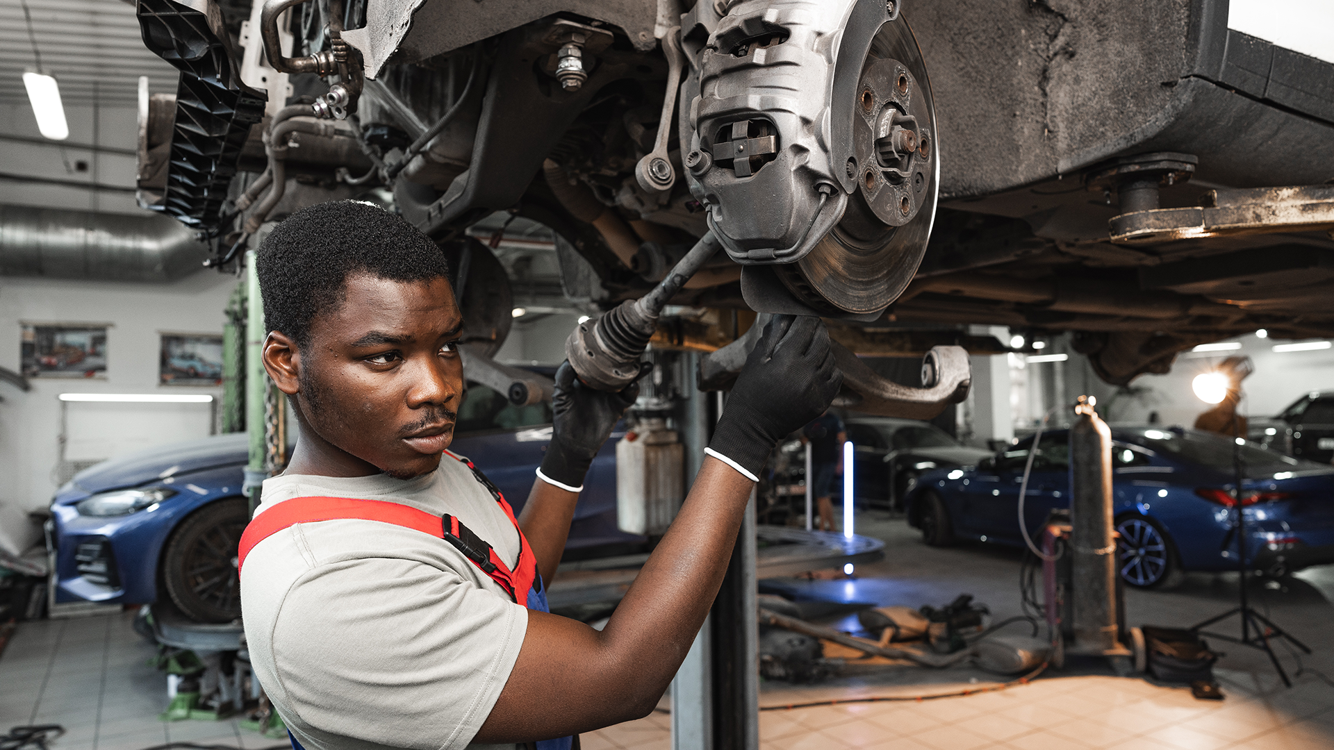 Automotive Repair Workshop | Brimco African male mechanic repairing a vehicles brake system in a professional automotive workshop