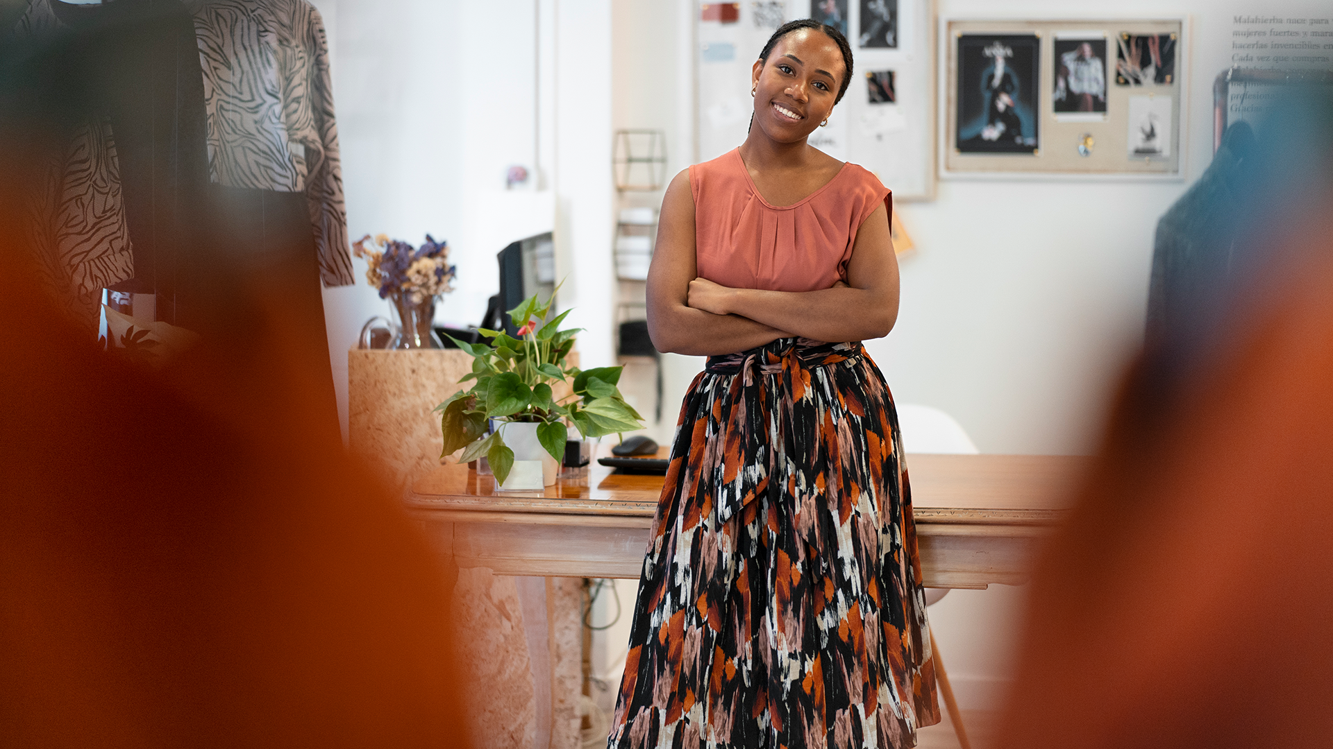 Clothing Boutique Business Owner | Brimco African female boutique owner standing confidently with folded arms inside her fashion store surrounded by stylish garments and decor