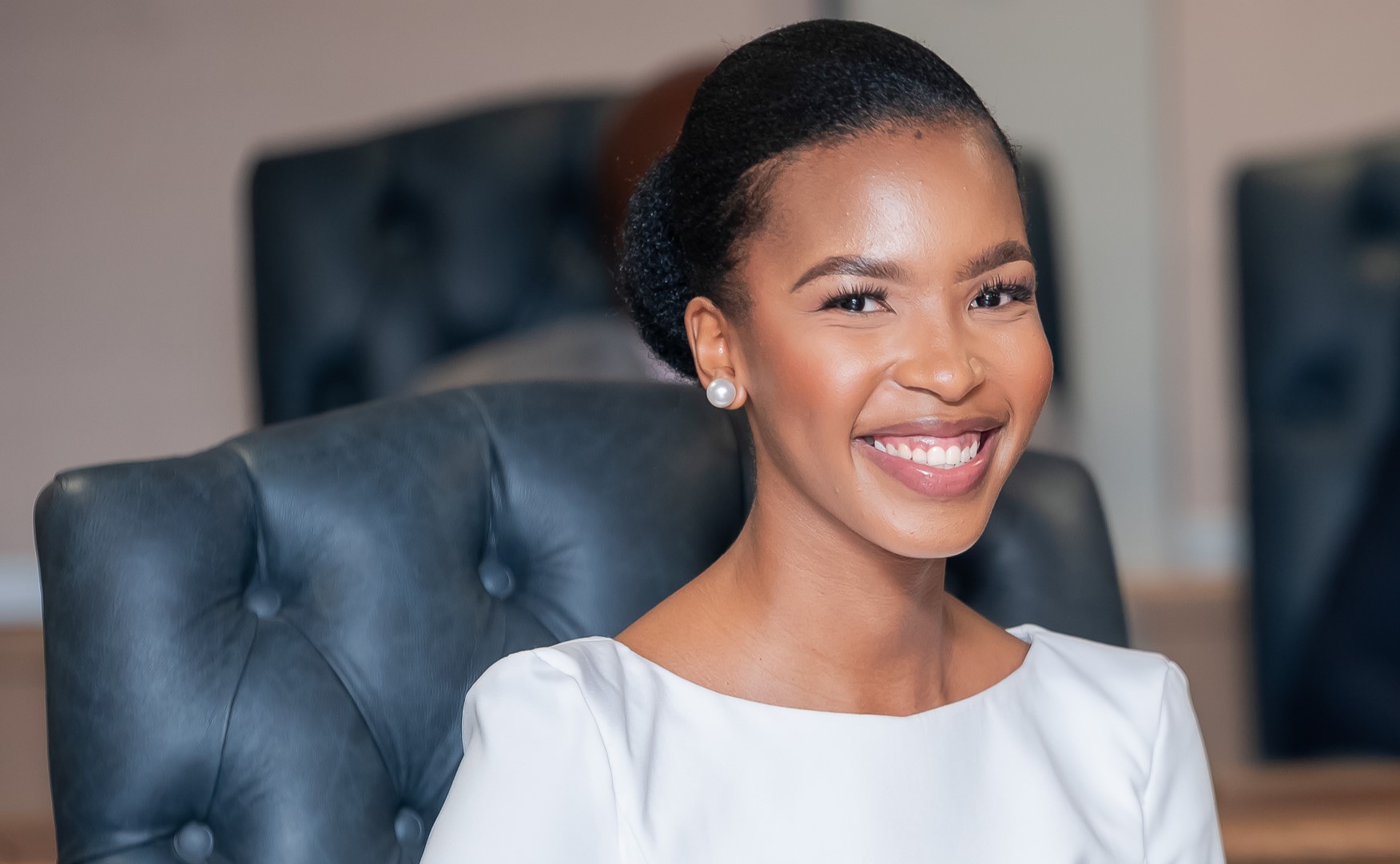 Minister of Youth and Gender Affairs - Lesego Chombo | Brimco Lesego chombo minister of youth and gender affairs smiling during her appointment ceremony dressed in a white outfit and seated in a formal setting