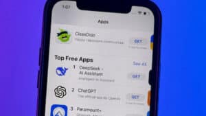 A smartphone screen showing the apple app stores top free apps with deepseek ai assistant ranked first chatgpt second and paramount+ third