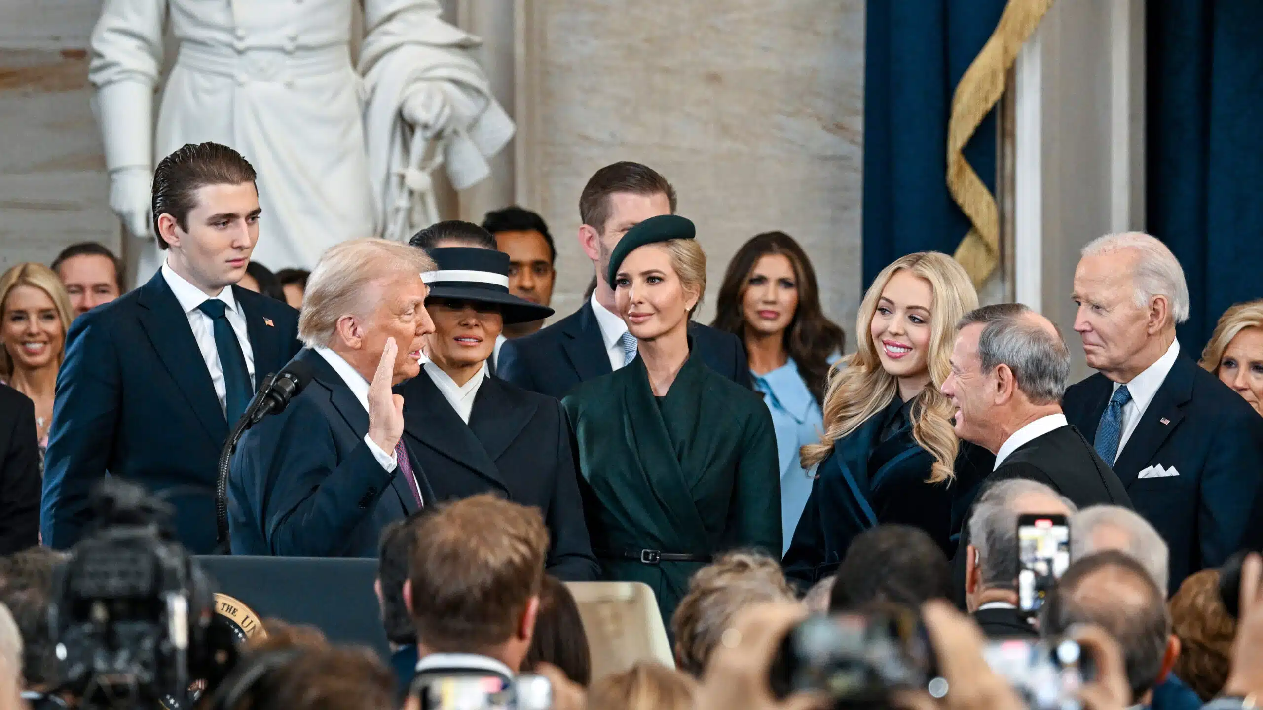 Donald trump is sworn in as the 47th president of the united states surrounded by his family as chief justice john roberts administers the oath during the inauguration ceremony