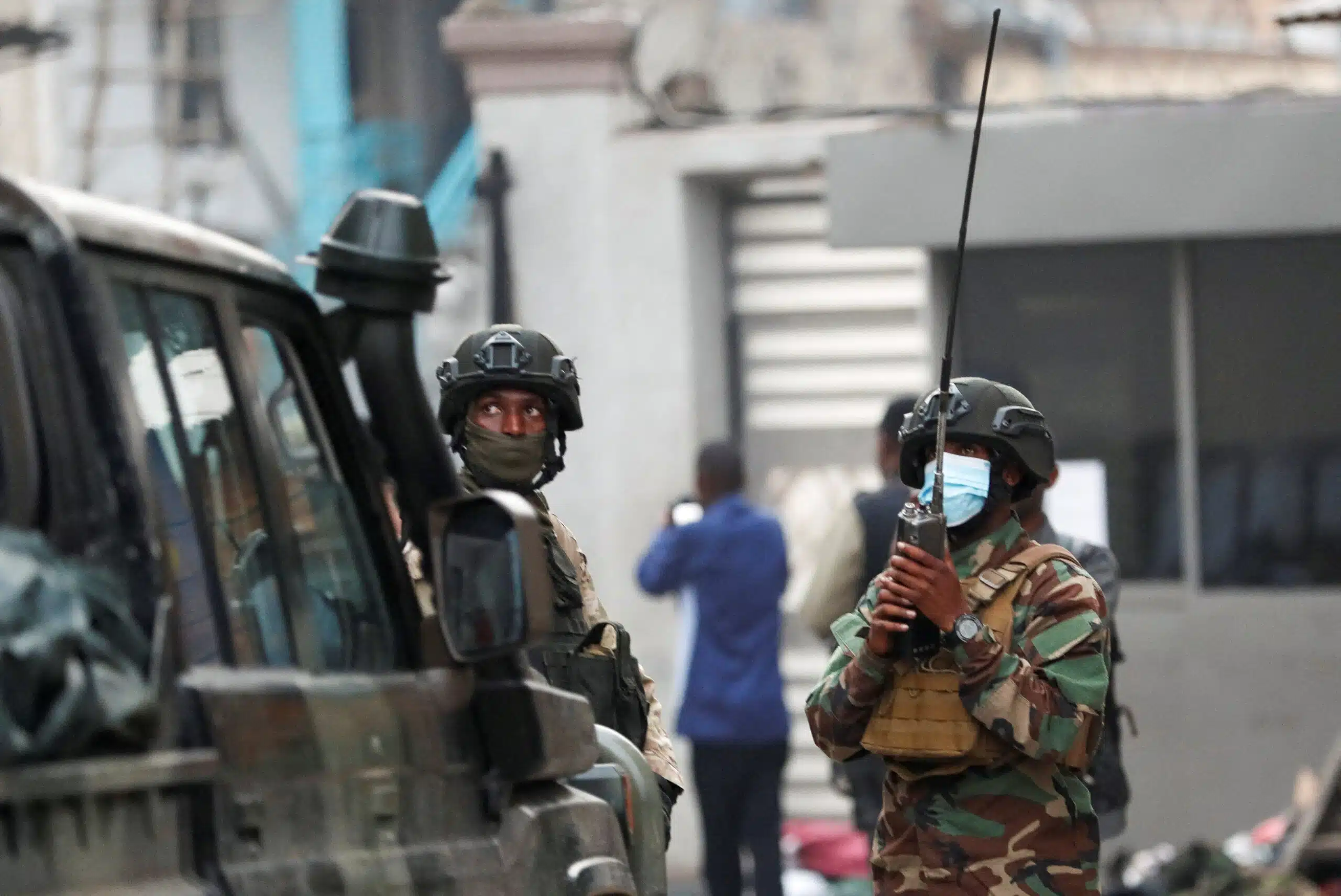 Members of the M23 rebel group in Goma | Brimco Armed m23 rebel fighters in camouflage uniforms and tactical gear stand near a military vehicle one holding a radio for communication amid ongoing clashes in goma drc