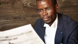 Focused businessman in botswana reading a newspaper with updates on the 2025 companies act amendments