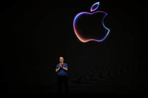 Apple ceo tim cook standing on stage under a glowing apple logo during a product launch event