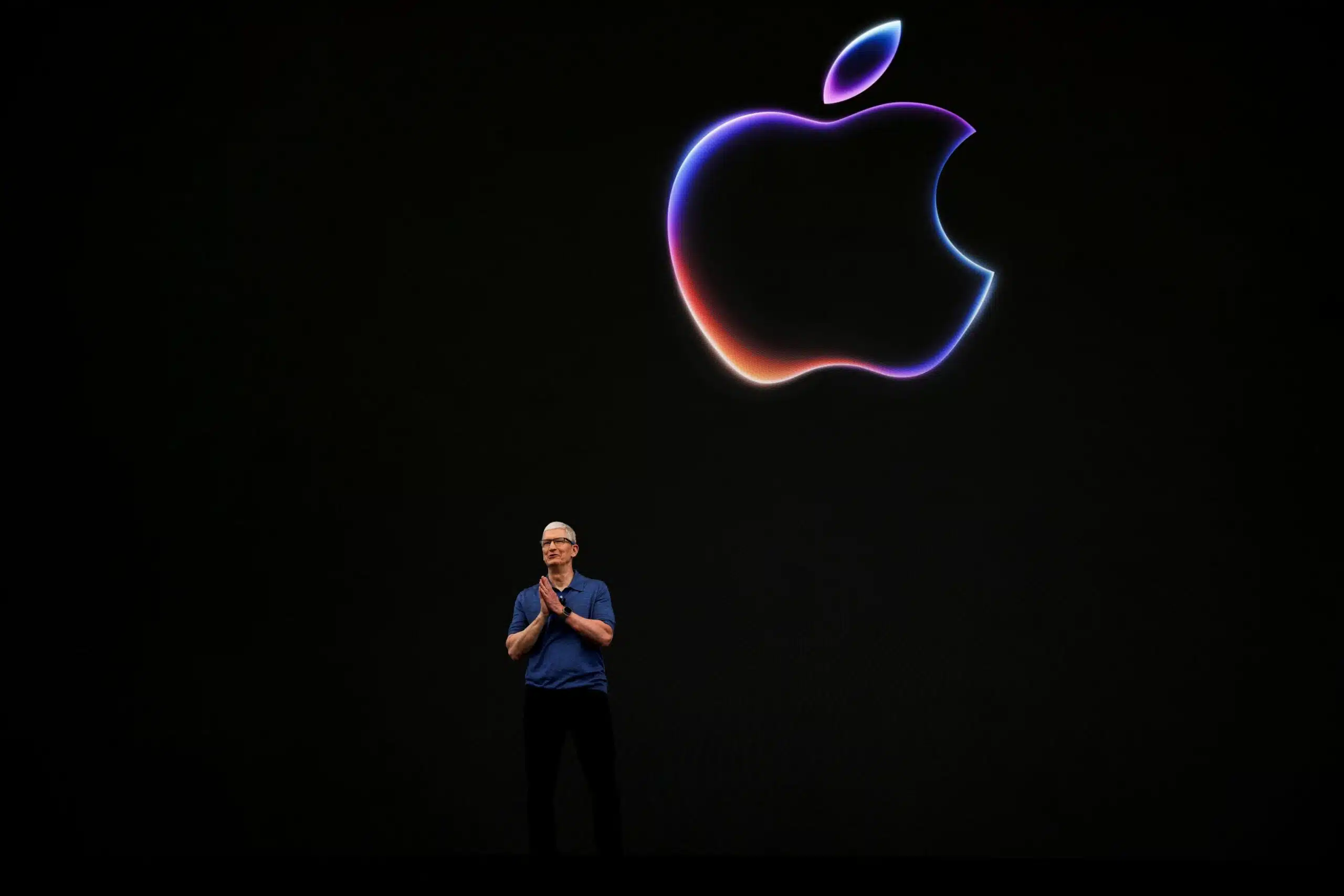 Apple CEO Tim Cook Unveils Innovation at Apple Event | Brimco Apple ceo tim cook standing on stage under a glowing apple logo during a product launch event
