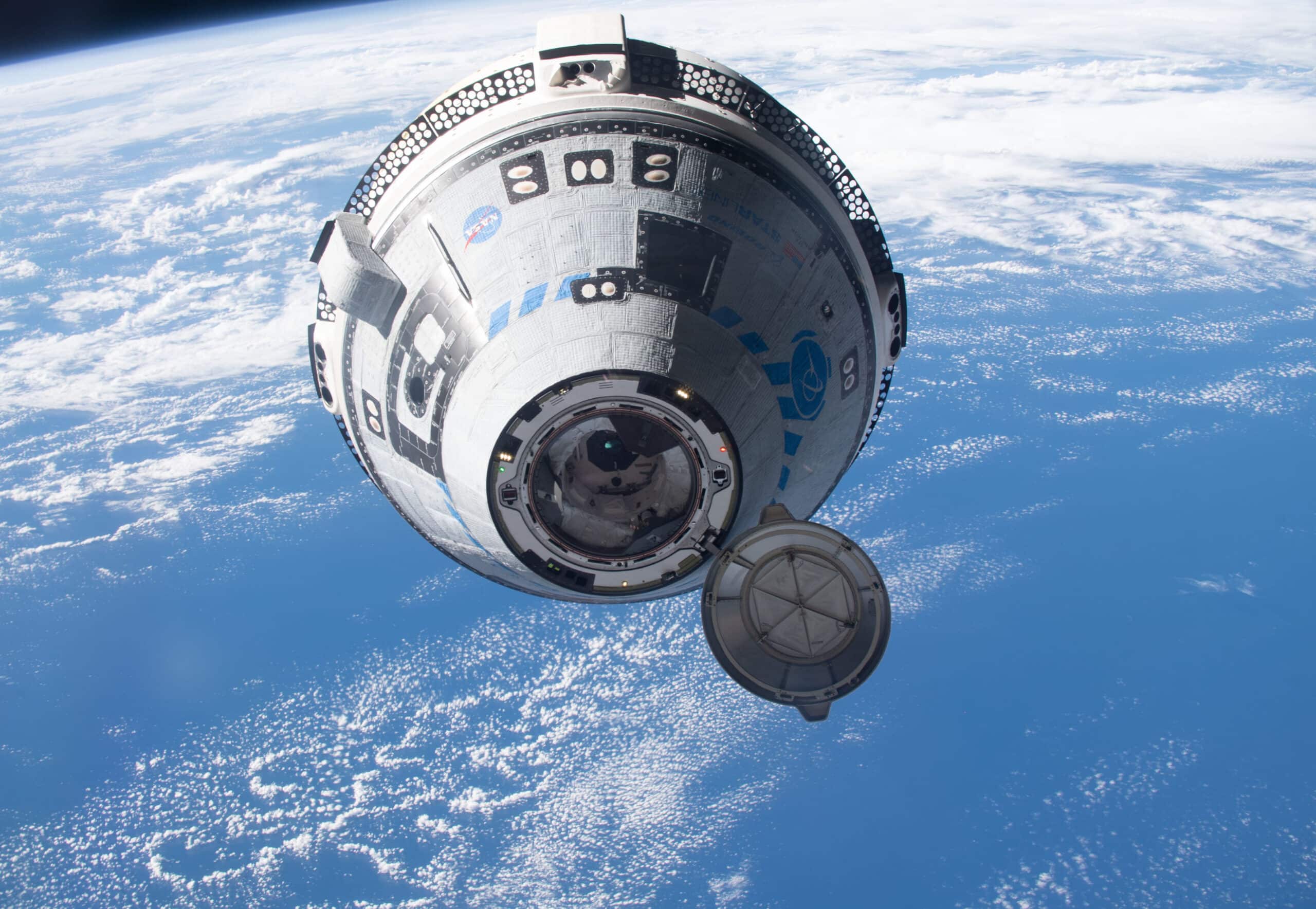 Boeing’s Starliner Approaches the International Space Station | Brimco Boeings starliner spacecraft with its docking port open approaching the international space station against the backdrop of earth