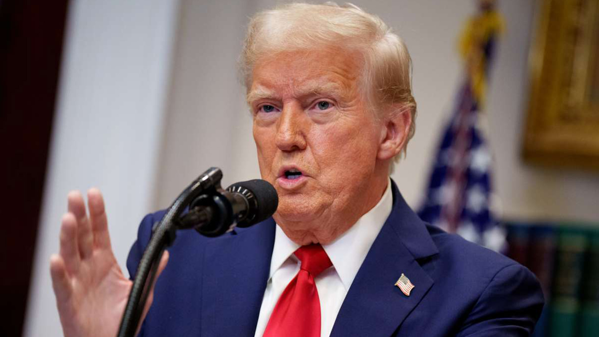 A Voice of Resolve - Trump Delivers National Address | Brimco Donald trump speaking into a microphone wearing a blue suit and red tie with the american flag in the background