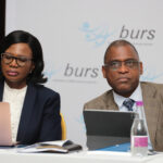 Jeanette makgolo and dr lesedi senatla seated side by side at a table with laptops in front of a backdrop displaying the burs logo