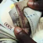 Close up of hands counting nigerian 1000 naira banknotes