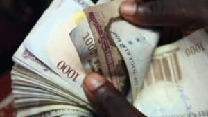 Close up of hands counting nigerian 1000 naira banknotes