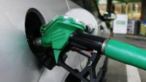 Close up of a green petrol nozzle fueling a silver car at a nigerian filling station