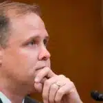 Jim bridenstine in a suit with hand on chin listening during a congressional hearing