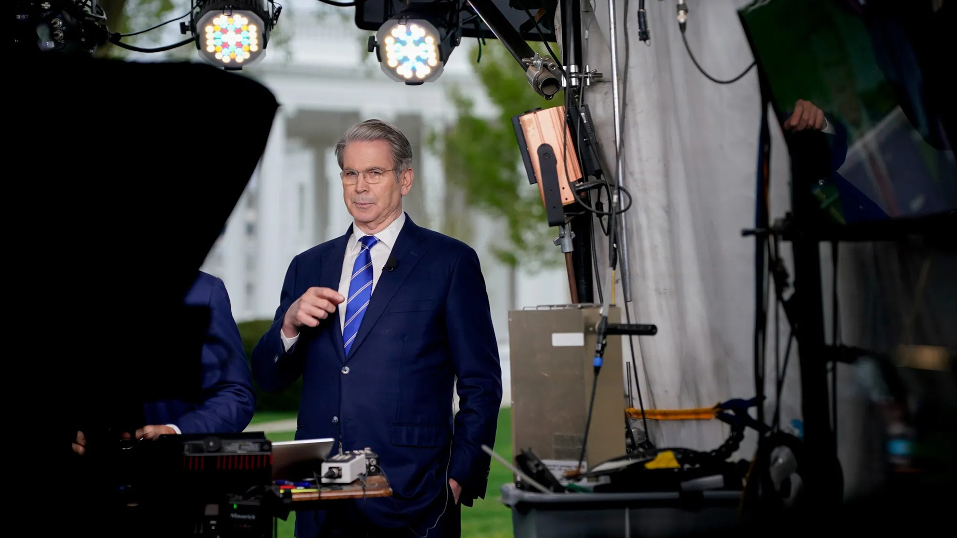 Scott Bessent Treasury Secretary Speaks on Economic Outlook | Brimco Scott bessent in a dark suit and green striped tie stands before cameras outside the treasury speaking and gesturing with his hands