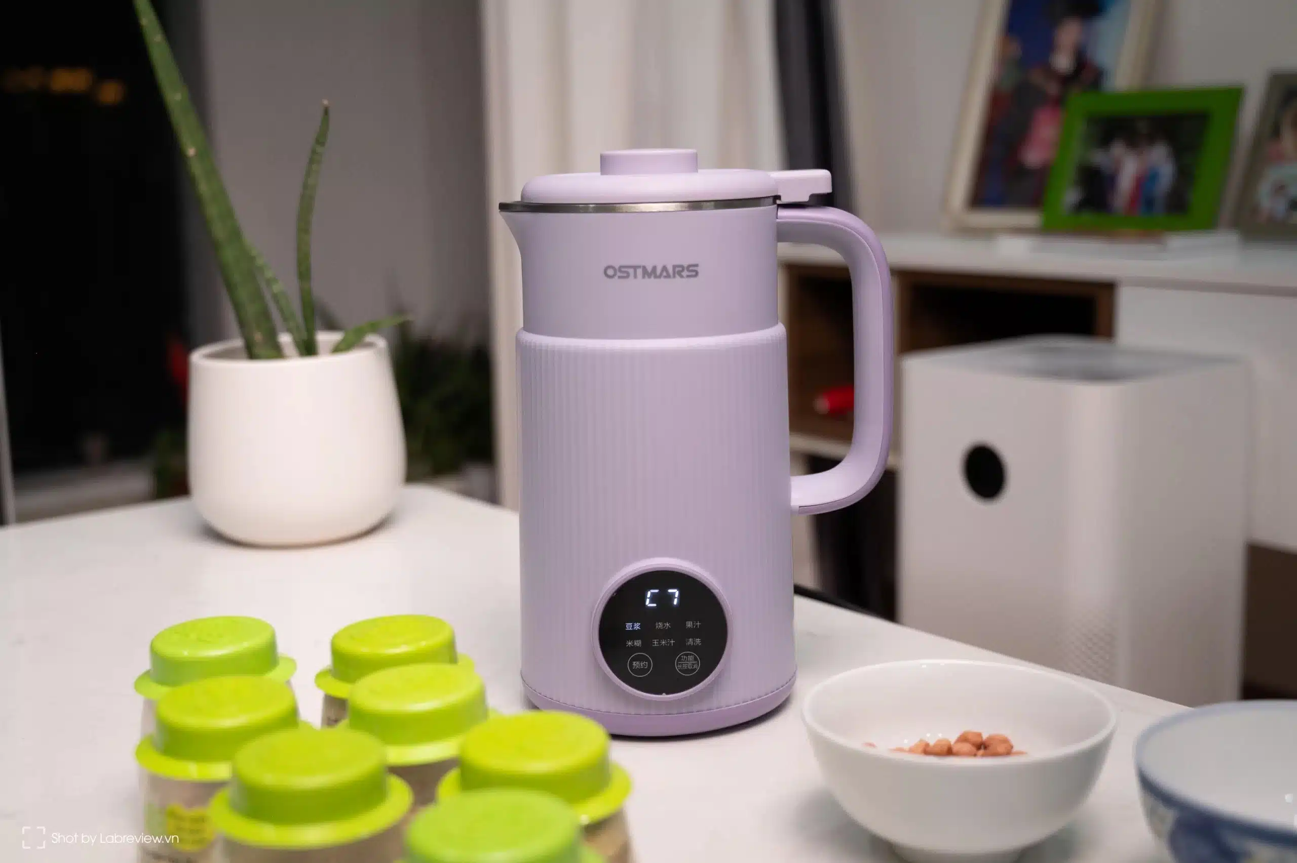 The OSTMARS Multi-Function Smart Blender | Brimco Lavender ostmars smart blender with digital display on a kitchen counter next to a bowl of peanuts and green lidded jars