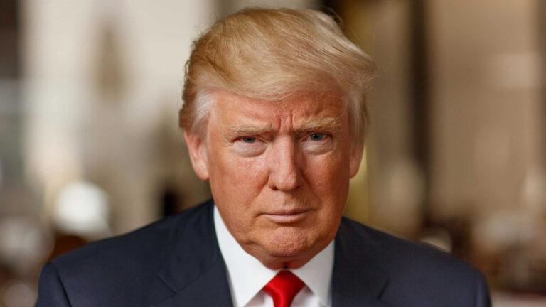 Portrait of President Donald Trump wearing a navy suit, white shirt, and red tie, facing the camera with a serious expression.