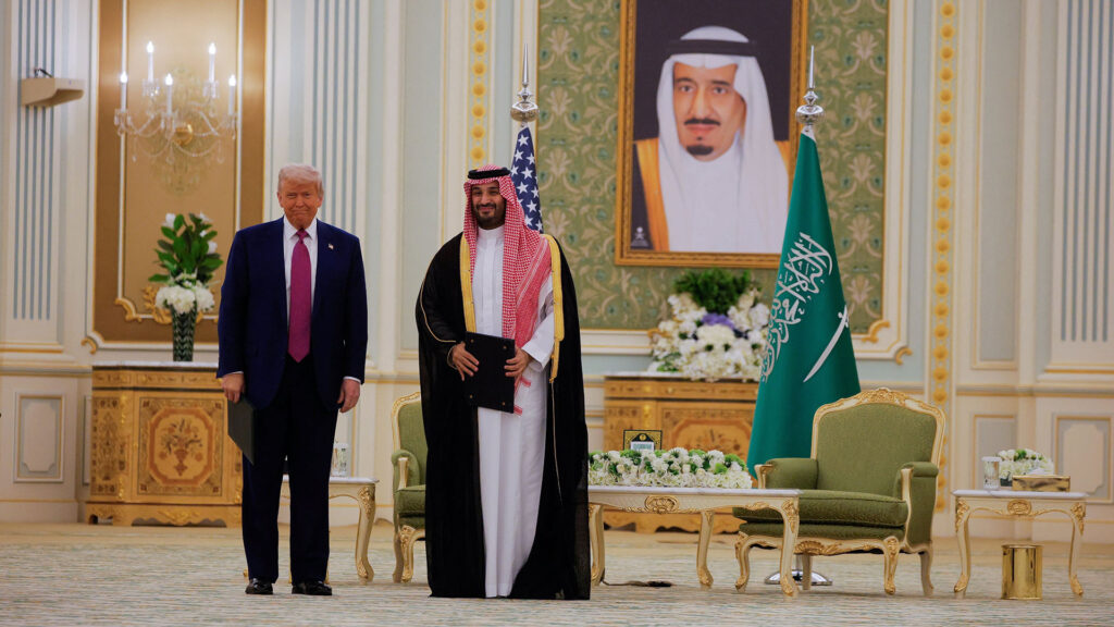 Donald trump and crown prince mohammed bin salman standing side by side at the saudi royal palace with the saudi flag and a portrait of king salman in the background