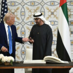 Donald trump and sheikh mohamed bin zayed al nahyan at a signing ceremony exchanging a pen as they formalize a strategic agreement between the united states and the united arab emirates