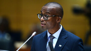 Botswana vice president ndaba gaolathe speaking at the national assembly podium in a navy suit and glasses