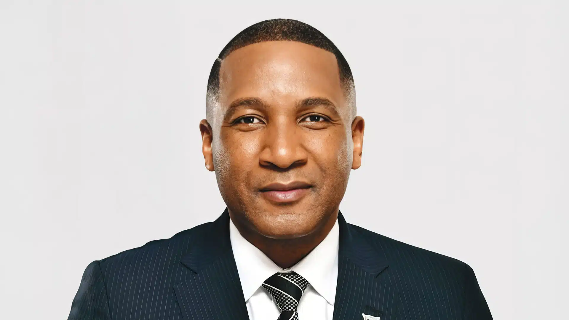 Portrait of president advocate duma gideon boko in a dark pinstriped suit and tie facing forward against a light background