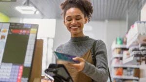 Smiling customer using a card at a modern point of sale system in a retail store