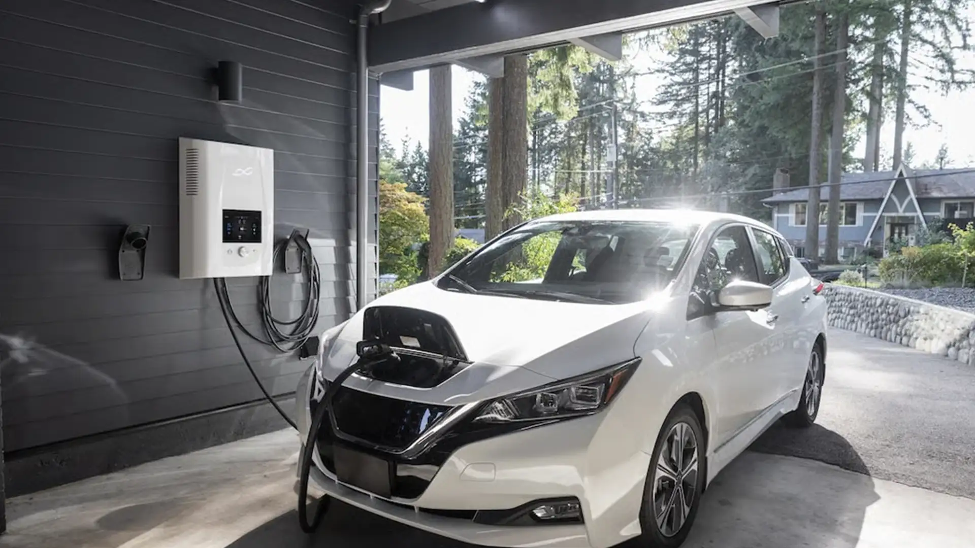Alt text white electric vehicle charging at a home garage with a wall mounted ev charger