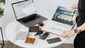Person reviewing architectural plans with material samples on a marble table
