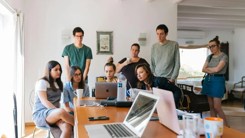 Young professionals collaborating around a laptop in a modern workspace