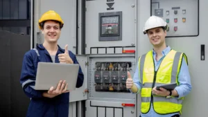 Two electrical engineers managing utility control systems with laptops and tablets