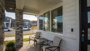 Front porch with chairs and table outside a modern suburban house