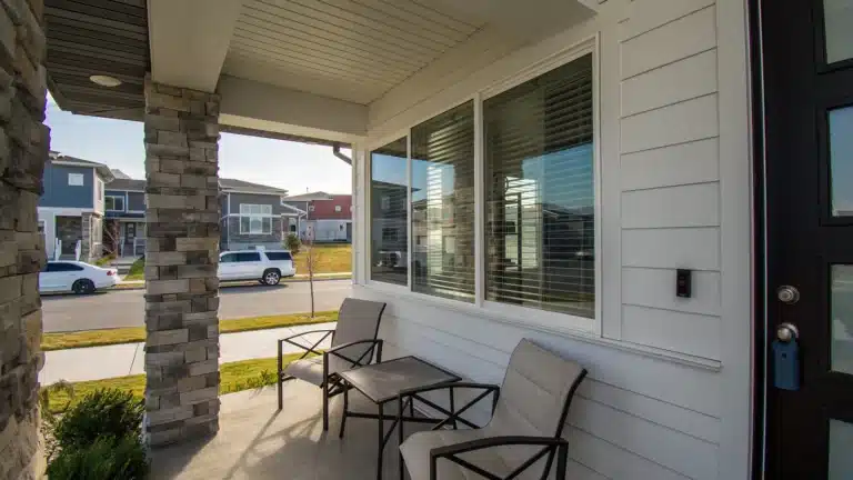 Front porch with chairs and table outside a modern suburban house