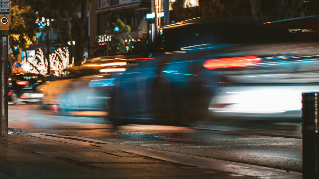 Blurry night view of speeding cars on city street