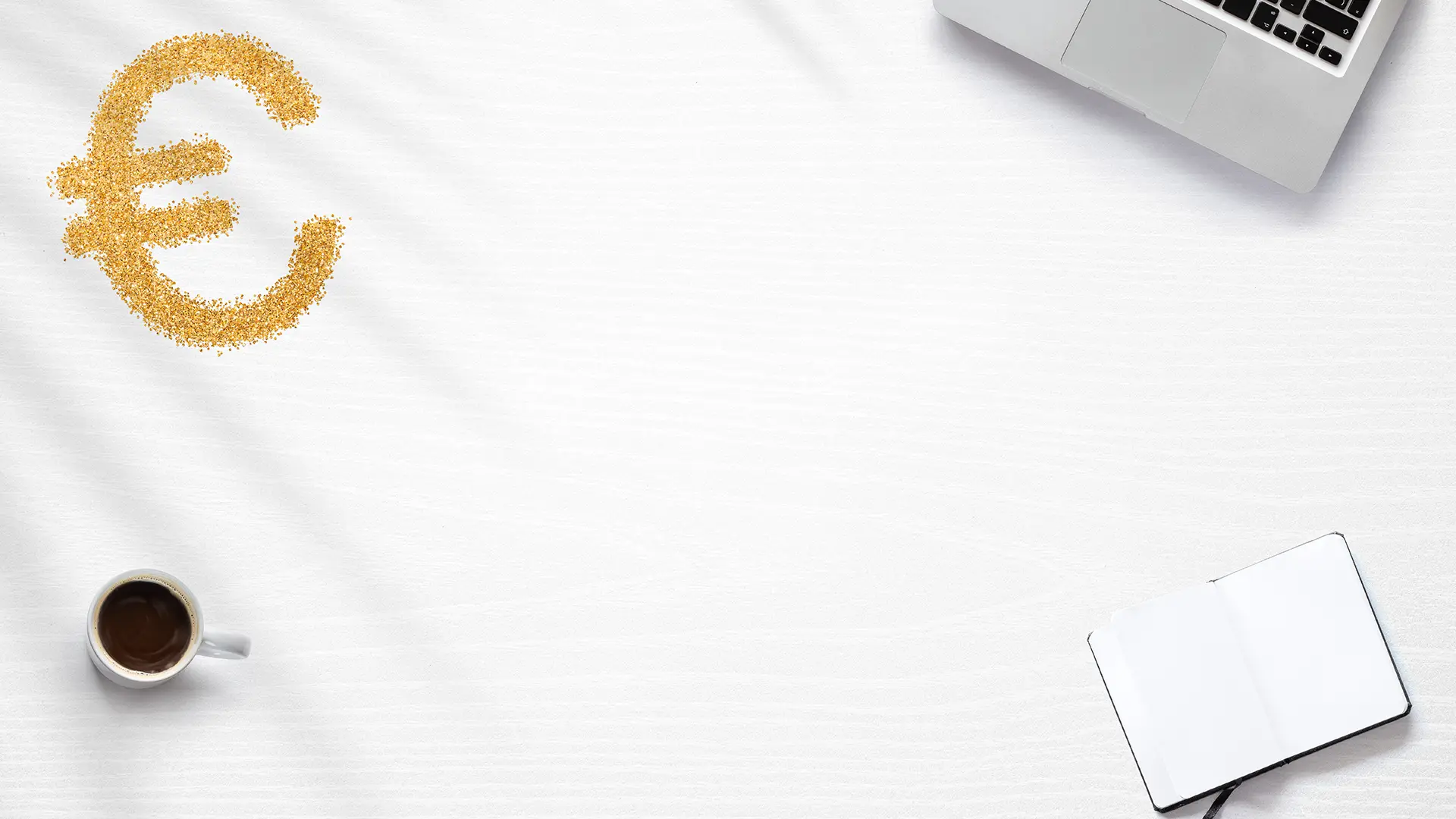 Gold euro currency symbol on white desk with coffee cup laptop and open notebook