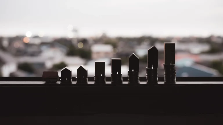 Real estate market growth represented by miniature house models on stacked coins