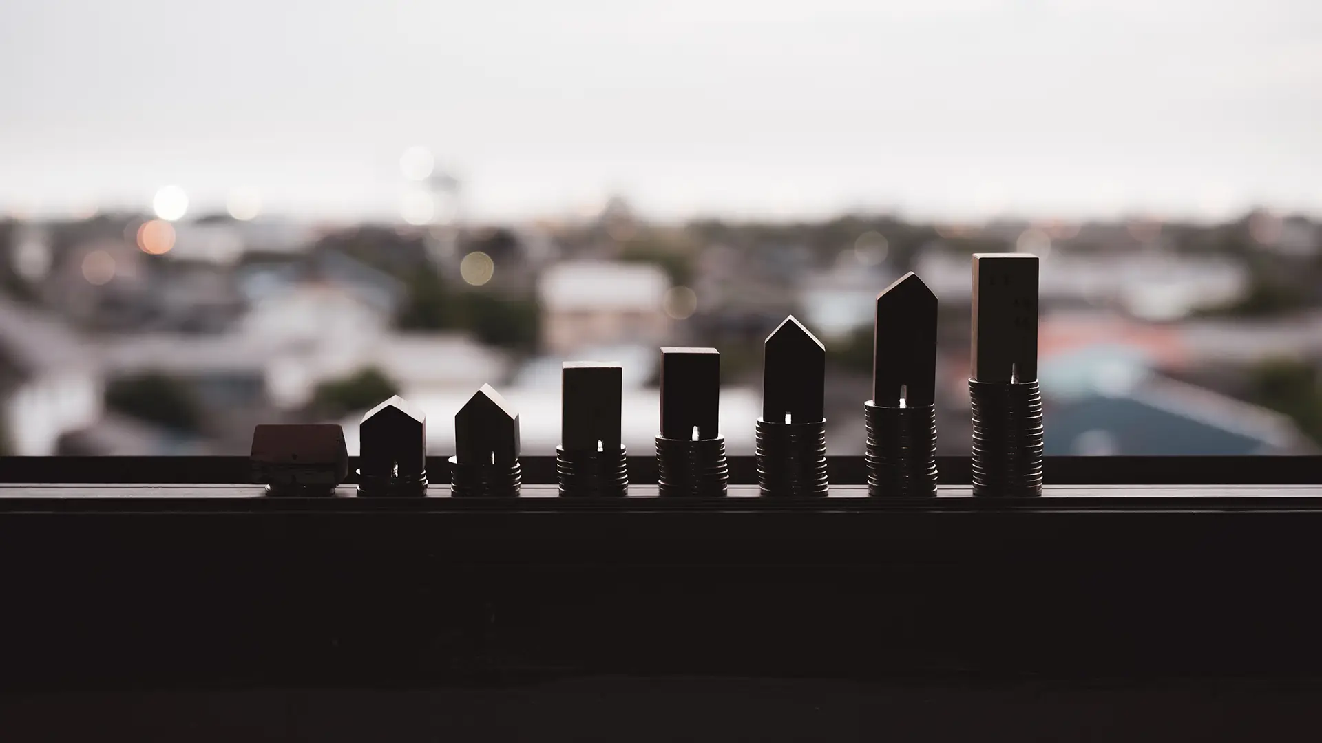 Real estate market growth represented by miniature house models on stacked coins