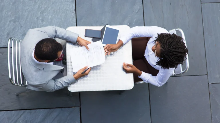 Business professionals signing documents at a meeting table