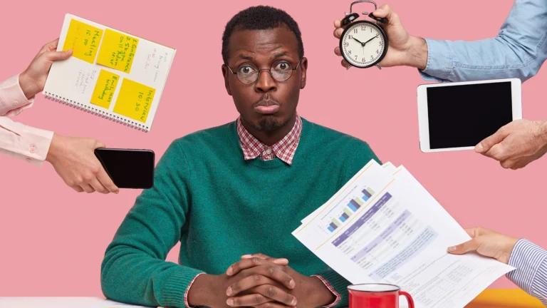 Stressed businessman surrounded by multiple tasks reminders and devices