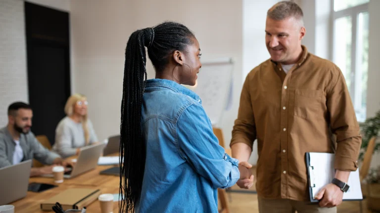 Two professionals shaking hands during a business meeting.
