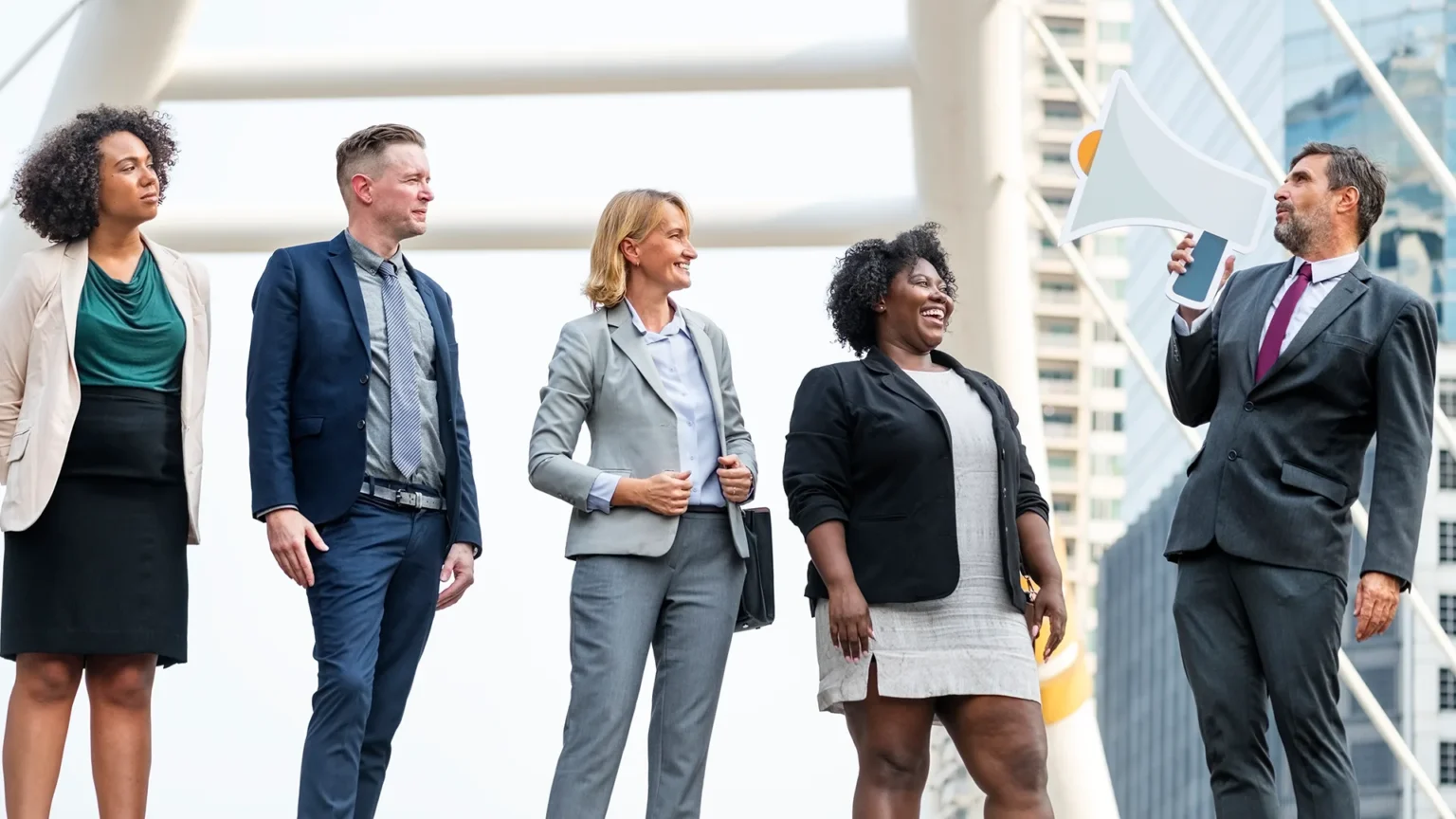 Group of business leaders standing outdoors one speaking through a megaphone