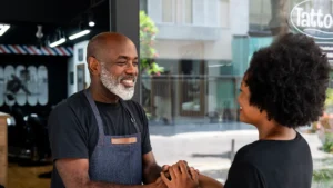 Smiling business owner greeting a customer outside his shop
