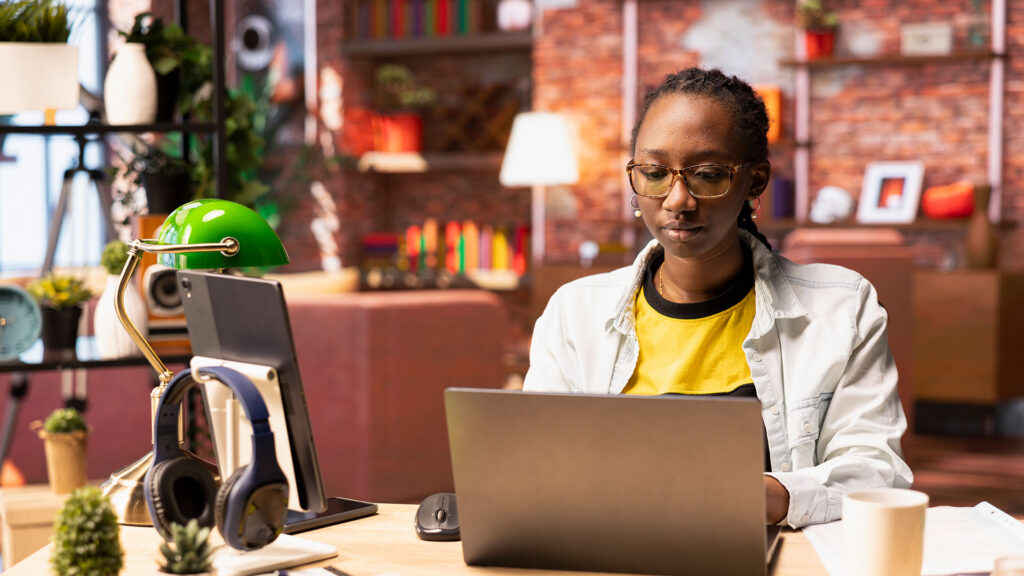 Remote worker typing on a laptop while preparing a presentation