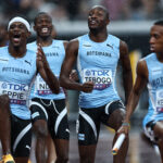 Botswana 4x400m relay team members Eppie, Ndori, Tebogo, and Kebinatshipi jubilantly celebrating their gold medal win in the rain at the 2025 World Championships in Tokyo.
