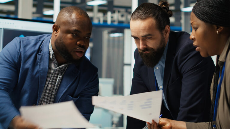 Business professionals reviewing financial documents together in a modern office setting