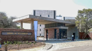 Entrance of the bank of botswana headquarters with security personnel and modern office buildings in the background